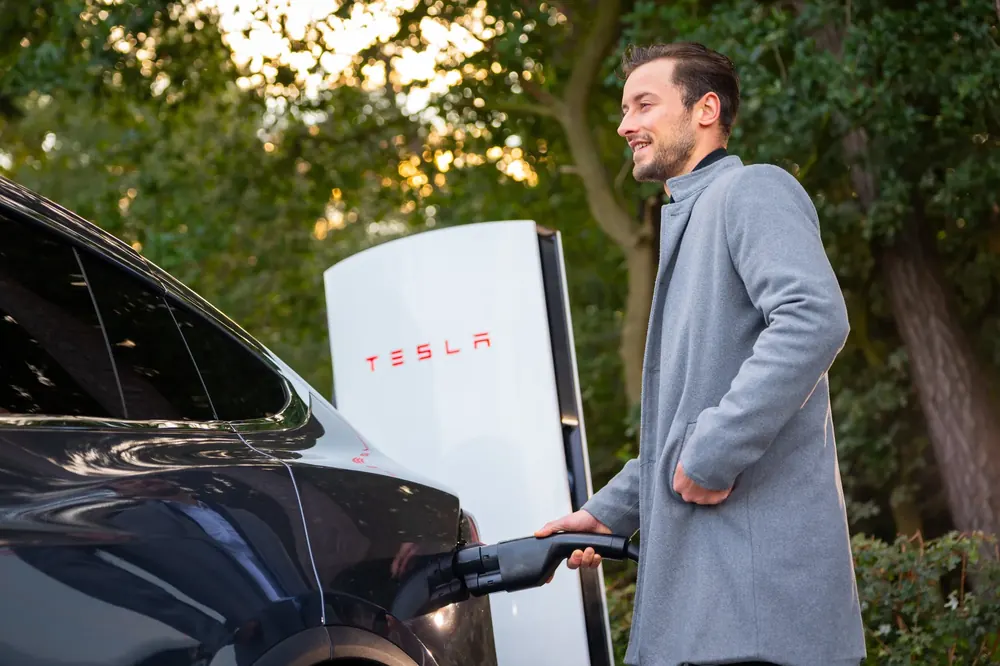 An electric car connected to a Supercharger cable