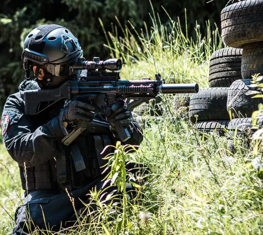 Airsoft Brothers player between the tyres and the tall grass