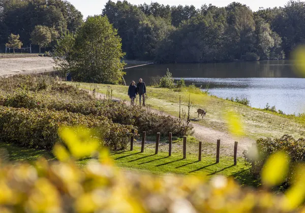 Walkers on a path along the water near Parkhotel Horst