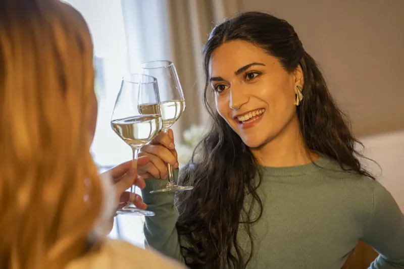 A guest raises a glass of wine in restaurant BØFF
